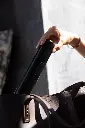 woman holding pomabrush black over handbag.webp